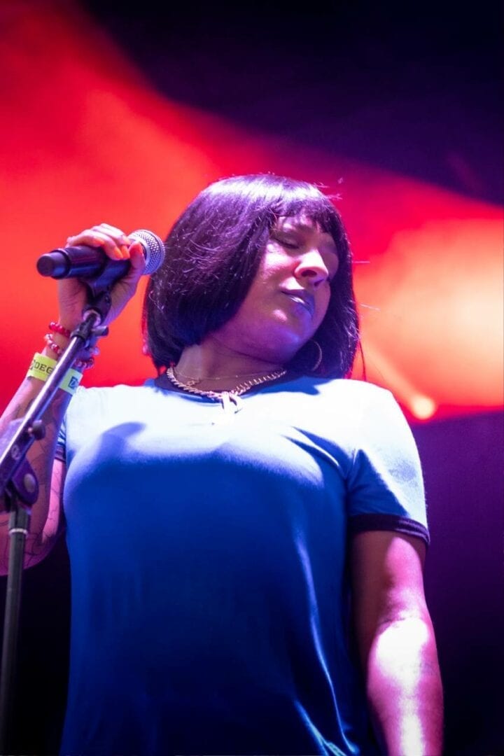 A woman singing into a microphone on stage.